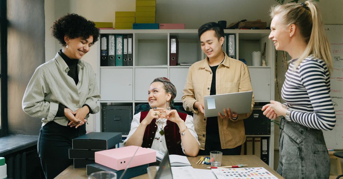 Colleagues engage in a lively discussion during a team meeting in a modern office setting.