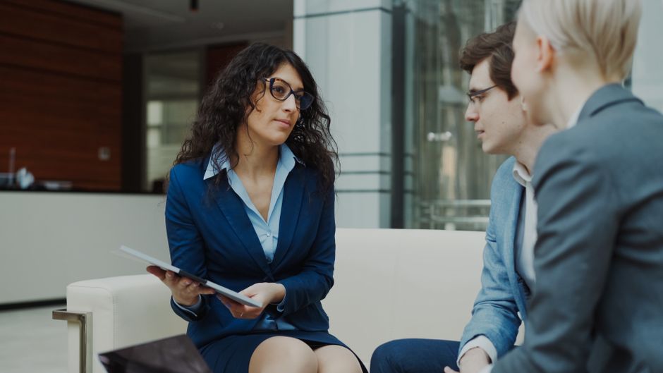 A professional meeting with a team discussing business strategies in a modern office setting.